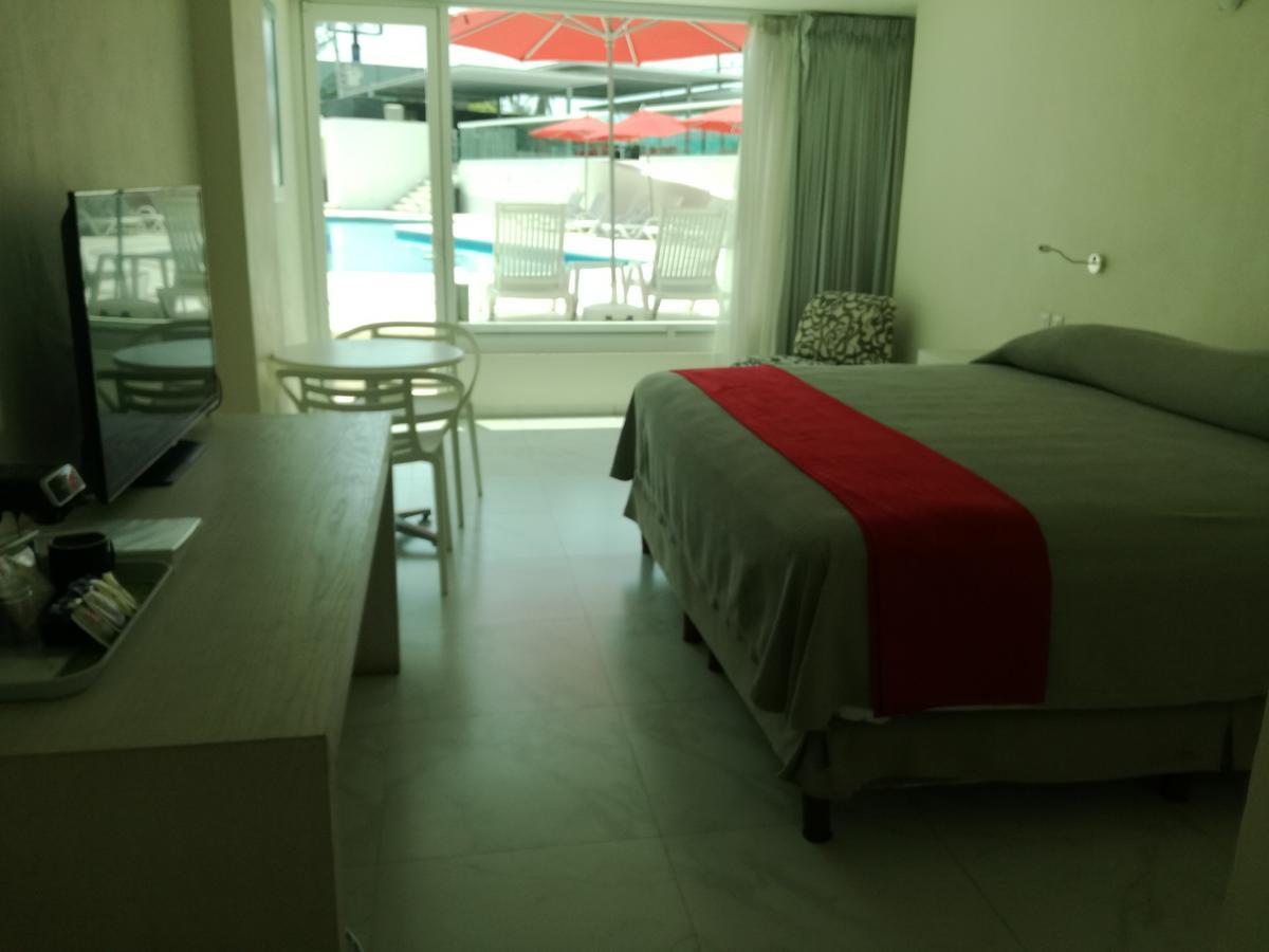 Habitación con cama extragrande y vistas a la piscina